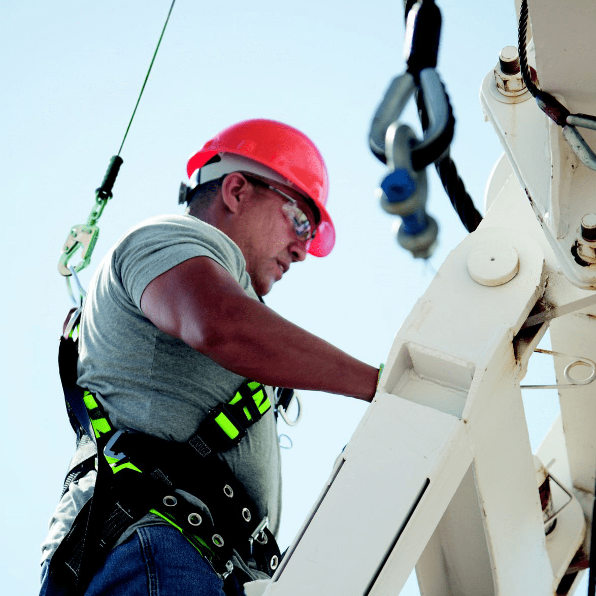 A person using a ladder safely, with proper footing and hand placement, demonstrating ladder safety practices.